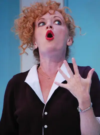 A woman with a black shirt on talks into her hand.